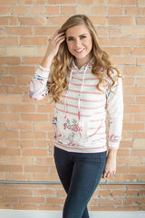 Model standing forward wearing floral hoodie